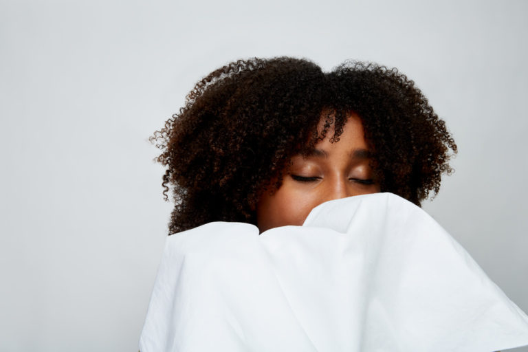 woman smelling sheets