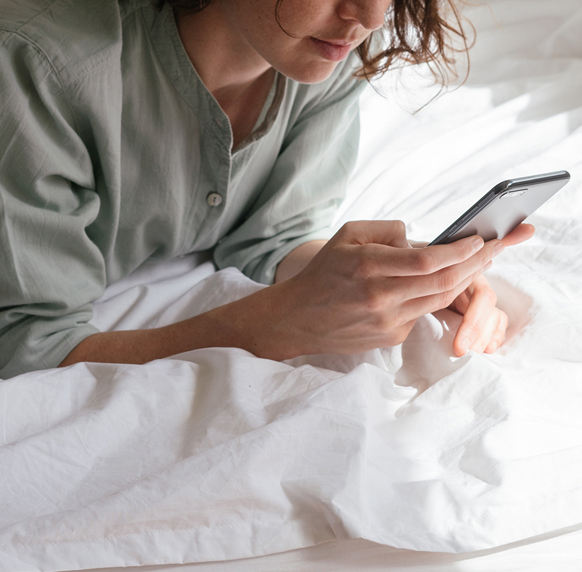 woman with phone on bed